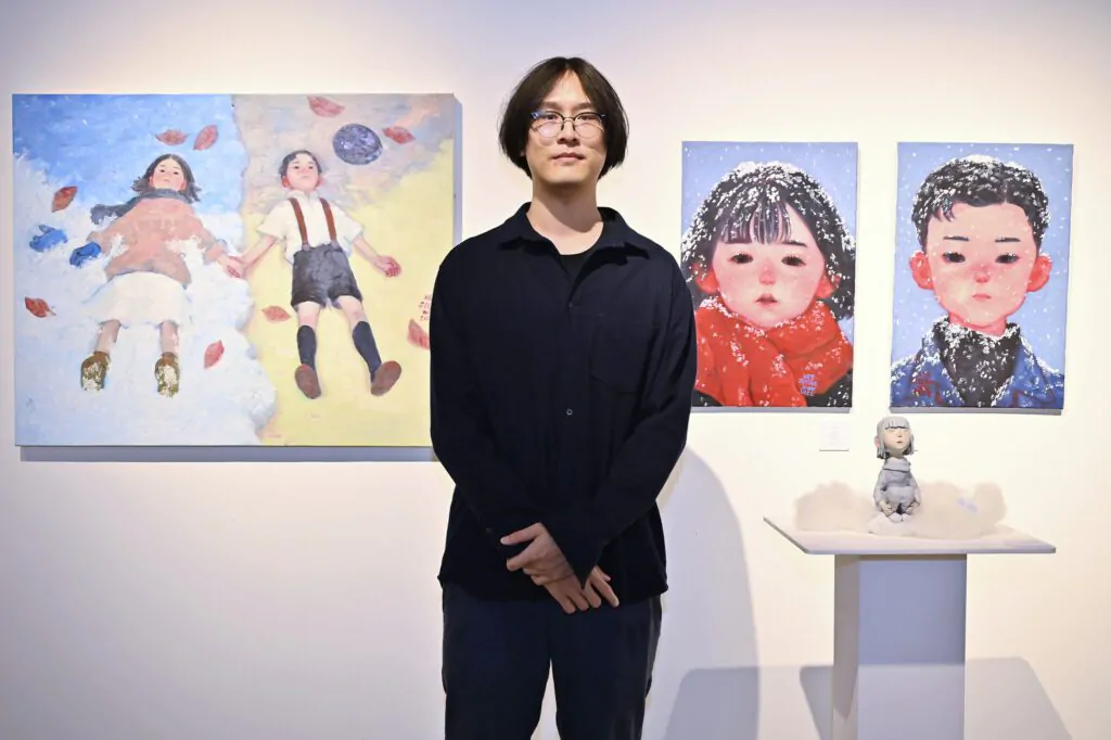 ภาพคุณอาร์ท Jeeno กับผลงานศิลปะที่เขาวาด เครดิตภาพจาก ริเวอร์ ซิตี้ แบงค็อก